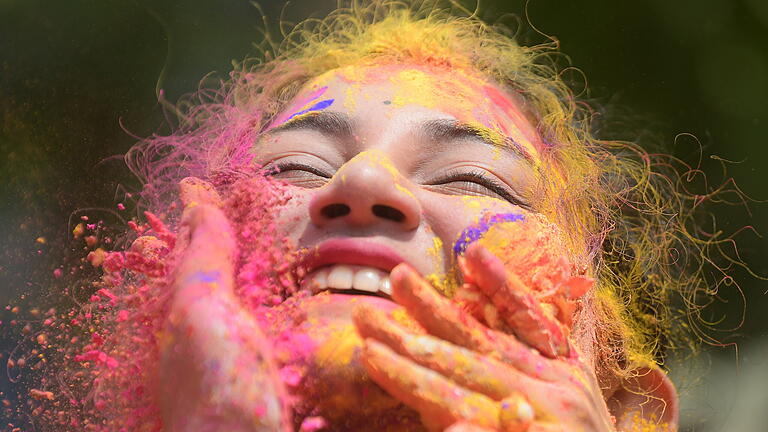 Frühlingsfest «Holi» in Indien.jpeg       -  Millionen Menschen konnten sich in Indien inzwischen aus der Armut befreien. Unser Bild zeigt ein Mädchen, das beim traditionellen Holi-Fest in Indien mit Farbpulver besprüht wird.