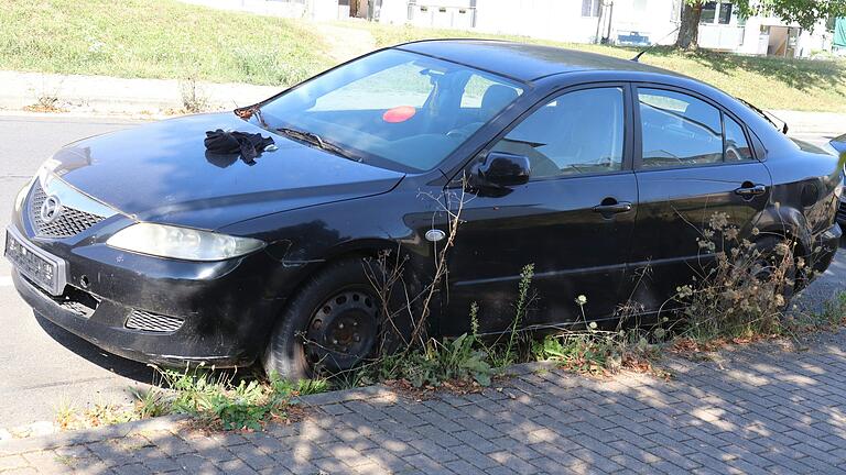 Dieser schwarze Mazda gammelt seit mehr als zwei Jahren am Straßenrand im Kitzinger Wohngebiet Marshall Heights vor sich hin.