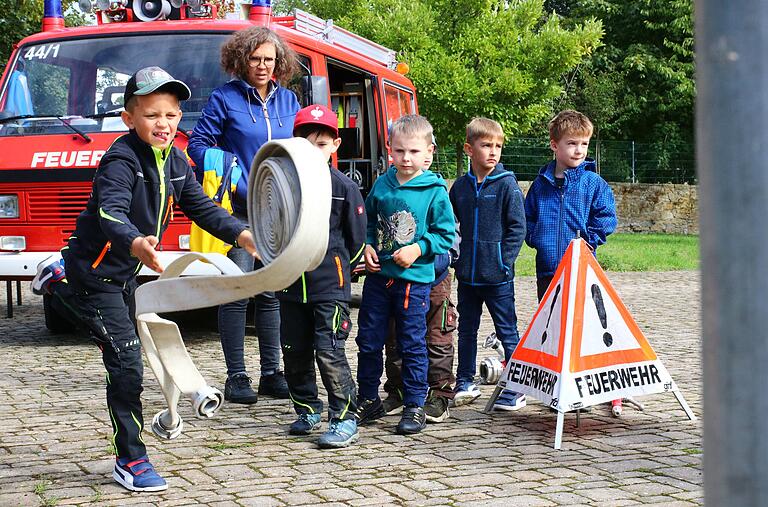 Aller Anfang ist schwer: Der siebenjährige Milo Friederich probiert sich am Schlauch ausrollen. Kinderfeuerwehrwartin Carina Lohmann beobachtet die ersten Schritte der Kirchschönbacher Löschkids. Aller Anfang ist schwer: Der siebenjährige Milo Friederich probiert sich am Schlauch ausrollen. Kinderfeuerwehrwartin Carina Lohmann beobachtet die ersten Schritte der Kirchschönbacher Löschkids.