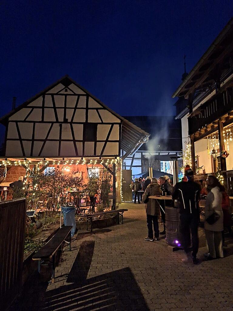 Der Hof von Winfried Eidel in Schonderfeld in adventlicher Beleuchtung mit Gästen an den Feuertonnen, links das Backhaus Der Hof von Winfried Eidel in Schonderfeld in adventlicher Beleuchtung mit Gästen an den Feuertonnen, links das Backhaus