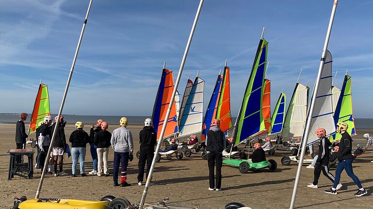 Gemeinsam genießen die deutschen und französischen Austausch-Schüler:innen das Strandsegeln am Strand von Saint-Brévin L'Océan in der Nähe von Pornic, Frankreich.