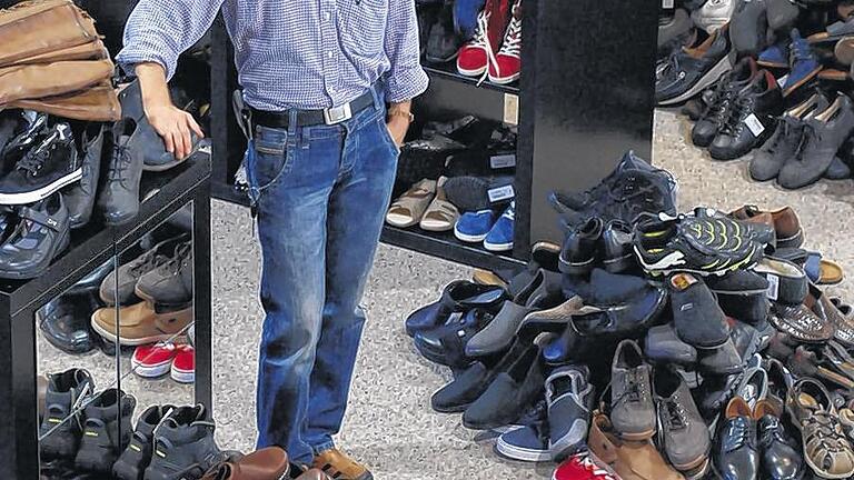 Sortieren für den Abverkauf: 18 Jahre betrieb Thomas Schantz sein Schuhgeschäft in Partenstein, zuletzt auch mit einer Filiale in Karlstadt. Nun verkündete er das bevorstehende Aus. Das Bild zeigt Schantz inmitten der Schuhberge, die derzeit für den Abverkauf im Partensteiner Geschäft sortiert werden. Foto: Johannes Ungemach