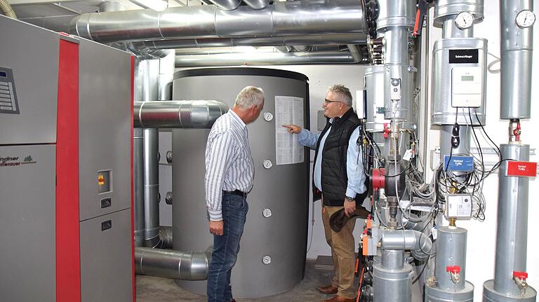 Die Zentrale des Nahwärmenetzes ist im Keller des Pfarrhauses untergebracht. Bürgermeister Willi Warmuth (rechts) und Bauhofleiter Manfred Storch inspizieren die Anlage mit den großen Wasserkesseln.