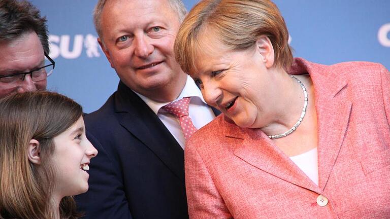 Gut gelaunt: Kanzlerin Angela Merkel scherzt bei ihrem Besuch Ende August in Bad Kissingen mit einem Mädchen. Im Hintergrund Unterfrankens CSU-Chef Gerhard Eck und Landrat Thomas Bold.