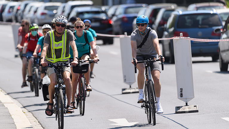 Pop-up-Fahrradweg-Demo       -  Ein paar Menschen befahren am Donnerstag (03.06.21) einen temporären Radweg in der Saalgasse in Würzburg. Die Stadt am Main ist eine von bundesweit 24 Städten, in denen am 3. Juni kurzzeitig als Demonstration Pop-up-Fahrradwege eingerichtet werden.