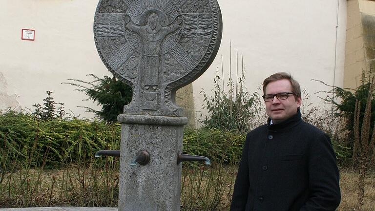 Dettelbachs Stadtpfarrer Uwe Hartmann neben dem Franziskusbrunnen im Klosterhof kurz vor seiner Amtseinführung im Jahr 2017. Dettelbachs Stadtpfarrer Uwe Hartmann neben dem Franziskusbrunnen im Klosterhof kurz vor seiner Amtseinführung im Jahr 2017.