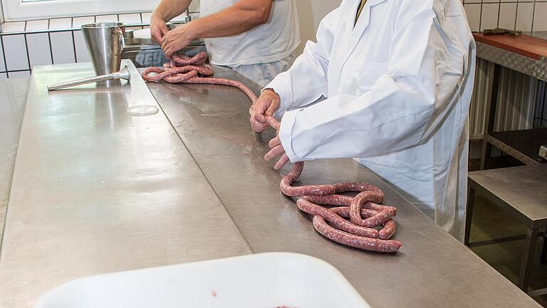 Das nächste Mal dann doch lieber kurzärmelig. Beim Bratwurstmachen ist es ganz wichtig , dass man den 'Dreh' raus hat. Was bei Michael Reck (im Hintergrund) in die Wurst kommt ist auch auf dem Hof aufgewachsen.