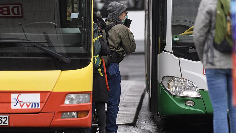 Eine Familie steigt am Freitag am Hauptbahnhof in Würzburg in einen Linienbus. Sie tragen Mundschutz, vermutlich um sich gegen das Coronavirus zu schützen.