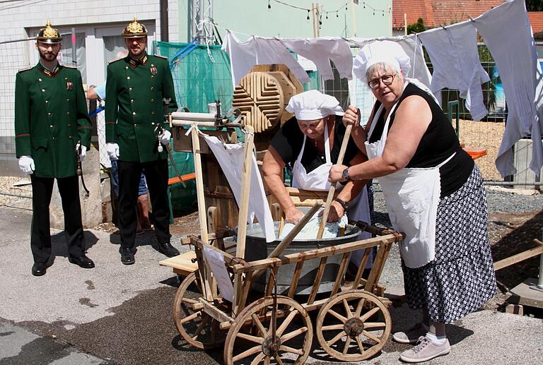 Die 'mobilen Aicher Waschweiber anno dazumal', daneben die Ortspolizisten in Grün.