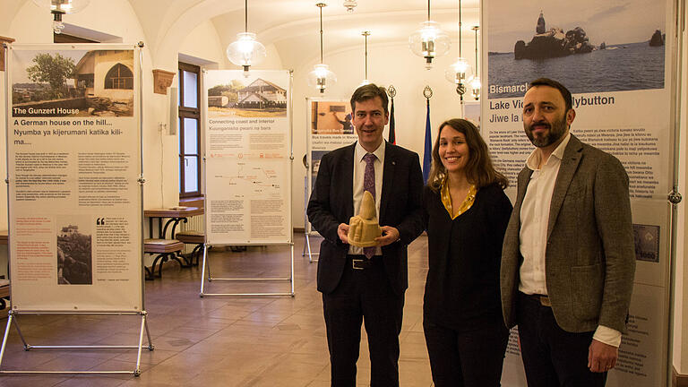 Oberbürgermeister Christian Schuchardt (links) mit einem Modell des Bismarck Rocks in Mwanza vor der Ausstellung im Oberen Foyer, gemeinsam mit Judith Schief (ASA-Teilnehmerin und Erstellerin der Ausstellung), Michal Kopriva (Würzburg International).