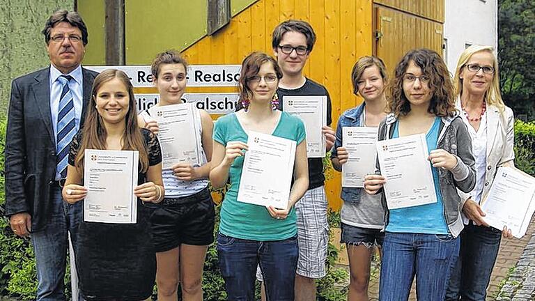 Zertifikat in Händen: Schulleiter Ulrich Kluge (links) und Lehrkraft Irmgard Seifert (rechts) gratulierten den Schülerinnen und Schülern der 9. Jahrgangsstufe der Ignaz-Reder-Realschule, Julia Krech (Zweite von links), Johanna Bauner, Bianca Hoffmann, Jonathan Trost, Stefanie Markert und Michaela Sarri (es fehlt Dominik Fries) zur erfolgreichen Teilnahme am so genannten Preliminary English Test (PET), einem weltweit anerkannten Sprachdiplom der britischen Universität Cambrigde.