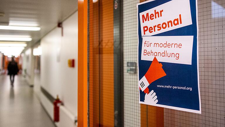 'Mehr Personal für moderne Behandlung' steht auf einem Schild an der Eingangstür der kinderpsychiatrischen Station der Uniklinik Würzburg.