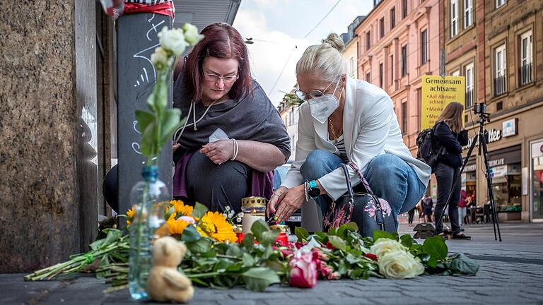 Viele Passanten legten bereits Blumen am Tatort nieder. Diese zwei Frauen zünden gerade Kerzen in Gedenken an die Opfer an.