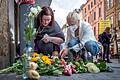 Viele Passanten legten bereits Blumen am Tatort nieder. Diese zwei Frauen zünden gerade Kerzen in Gedenken an die Opfer an.