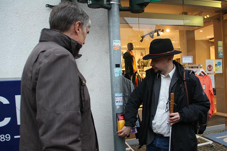 Karl Depner (rechts) weist Thomas Vizl, den Fraktionsvorsitzenden von Geo-net, an der Fußgänger-Ampel in der Grabenstraße auf das Fehlen eines akustischen Auffinde-Signals hin. Karl Depner (rechts) weist Thomas Vizl, den Fraktionsvorsitzenden von Geo-net, an der Fußgänger-Ampel in der Grabenstraße auf das Fehlen eines akustischen Auffinde-Signals hin.