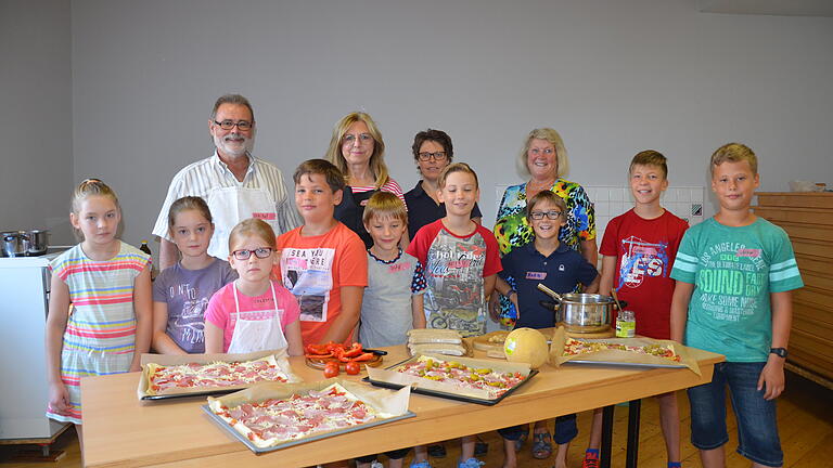 SPD-Ortsverein Kleinrinderfeld und Freie Bürger Kleinrinderfeld organisierten einen Ferien-Kochkurs für Kinder. Das Foto zeigt die neun Nachwuchstalente gemeinsam mit ihren vier Lehrmeistern (hinten, von links) Hans-Karl Karches, Gudrun Wallrapp, Monika Fleuchaus und Angelika Thürmer. Foto: Ulrich Stadlbauer SPD-Ortsverein Kleinrinderfeld und Freie Bürger Kleinrinderfeld organisierten einen Ferien-Kochkurs für Kinder. Das Foto zeigt die neun Nachwuchstalente gemeinsam mit ihren vier Lehrmeistern (hinten, von links) Hans-Karl Karches, Gudrun Wallrapp, Monika Fleuchaus und Angelika Thürmer. Foto: Ulrich Stadlbauer