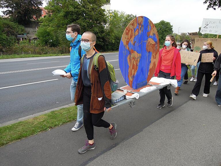 Symbolisch wurde 'der kranke Planet Erde' auf einer Trage bei der Fridays for Future-Demonstration auf den Marktplatz getragen.