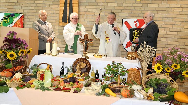 Der Mitarbeiterkreis mit Pfarrhelfer Elmar Fries an der Spitze hatte einen wunderschönen Erntedankaltar mit Obst, Gemüse, Feldfrüchte und Säften hergerichtet, im Bild von Pfarrer Wolfgang Bier gesegnet, assistiert von Diakon Wolfgang Krug und den Ministranten Ernst Reusch (links), dem ehemaligen Chef des Sonntagsblattes und Hermann Scheller (rechts).