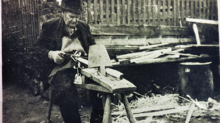 Haumeister Otto Hofmann schnitzte 1948 vor seinem Wohnhaus an seiner Hobelbank Besenstiele. Er flocht auch Körbe. Haumeister Otto Hofmann schnitzte 1948 vor seinem Wohnhaus an seiner Hobelbank Besenstiele. Er flocht auch Körbe.