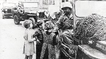 Die amerikanischen Soldaten befreiten Deutschland       -  Die amerikanischen Soldaten befreiten Deutschland von der Naziherrschaft. Nachdem das so genannte Fraternisierungsverbot gelockert worden war,
war es den Soldaten gestattet, mit den Kindern zu sprechen. Auf dem Bild verteilt ein farbiger Soldat Süßigkeiten.