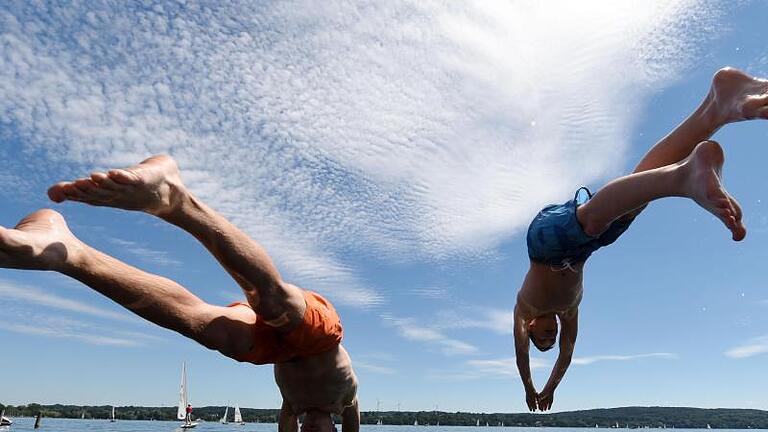 Bilderbuchwetter: Sprung in den Starnberger See. Foto: Tobias Hase       -  Am Wochenende soll die Temperatur in Bayern auf bis zu 30 Grad steigen.