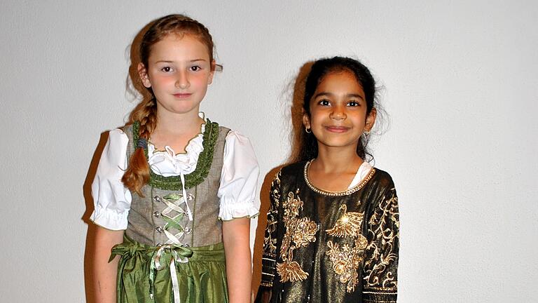 Zwei Mädchen, zwei Kulturen: Ein Dirndl zeigte Alina Schmitt (acht Jahre), ein pakistanisches Festtagsgewand die siebenjährige Laiba Chaudhry.