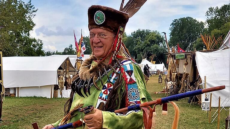 Bei einem Treffen präsentiert sich Edwin Wild in seinem selbst angefertigten Outfit mit Turban und Warshirt sowie der großen Friedenspfeife.