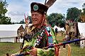 Bei einem Treffen präsentiert sich Edwin Wild in seinem selbst angefertigten Outfit mit Turban und Warshirt sowie der großen Friedenspfeife.