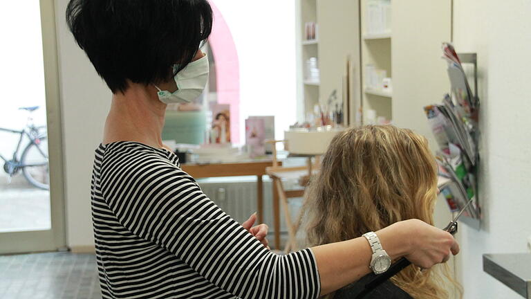 Claudia Benkert frisiert im Salon Bonetti mit Mundschutz.