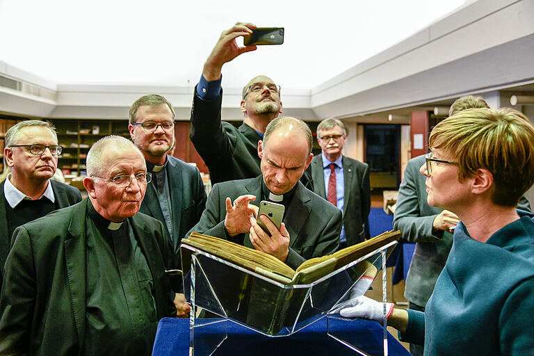 Abgelichtet: Expertin Kerstin Kornhoff erklärt eine altirische Handschrift, Bischof Franz Jung zückt das&nbsp; Smartphone und fotografiert.