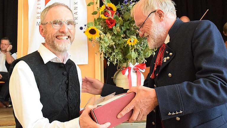 Worte des Dankes und ein Weinpräsent überbrachte der Vorsitzende der Arbeitsgemeinschaft Fränkische Volksmusik Unterfranken Reinhard Hüßner (rechts) an Armin Griebel. Worte des Dankes und ein Weinpräsent überbrachte der Vorsitzende der Arbeitsgemeinschaft Fränkische Volksmusik Unterfranken Reinhard Hüßner (rechts) an Armin Griebel.