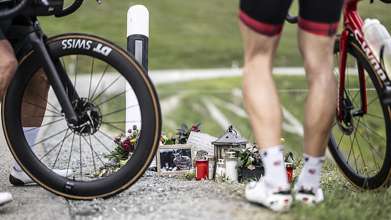 Unfallstelle Gino Mäder.jpeg       -  Radfahrer stehen am Unfallort des verunglückten Radfahrers Mäder auf dem Albulapass, an dem Blumen und ein Brief abgelegt wurden. Der Schweizer Gino Mäder vom Team Bahrain Victorious stürzte tödlich bei der Abfahrt vom Albulapass.