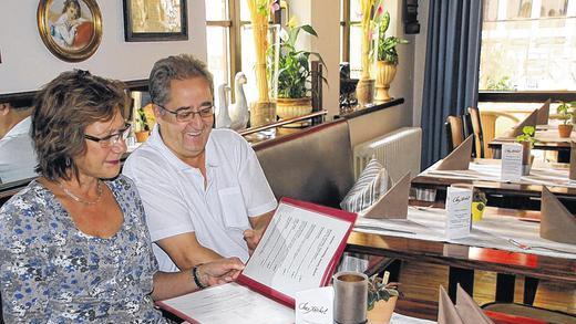 Blick in die Speisekarte: Michel Schultze und seine Lebensgefährtin Birgit Spies in ihrem Bistro &bdquo;Chez Michel&ldquo;. Im Herbst werden die beiden das Lokal in andere Hände übergeben.