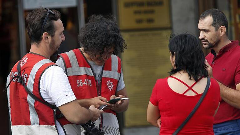 Türkische Polizeibeamte überprüfen die Dokumente von Fußgängern in Istanbul. Der vor zwei Jahren in der Türkei verhängte Ausnahmezustand ist beendet. Ankara hat für die Zeit danach aber bereits neue Anti-Terror-Regularien vorbereitet. Foto: Lefteris Pitarakis/AP       -  Türkische Polizeibeamte überprüfen die Dokumente von Fußgängern in Istanbul. Was müssen Touristen beachten?