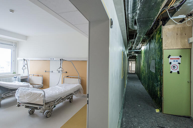 Links ist die Tür zum fertigen Patientenzimmer geöffnet, im Flur rechts ist ein Teil des Altbaues eingehaust für weitere Bauarbeiten. Links ist die Tür zum fertigen Patientenzimmer geöffnet, im Flur rechts ist ein Teil des Altbaues eingehaust für weitere Bauarbeiten.