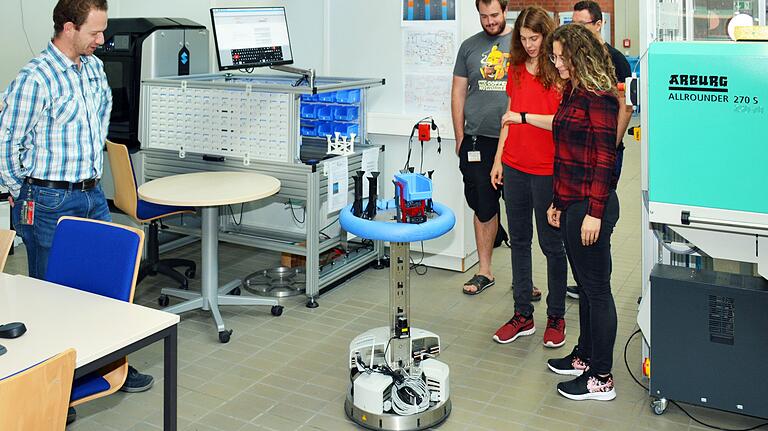Studierende arbeiten in der 'c-factory' mit einem autonomen Roboter. Studierende arbeiten in der 'c-factory' mit einem autonomen Roboter.