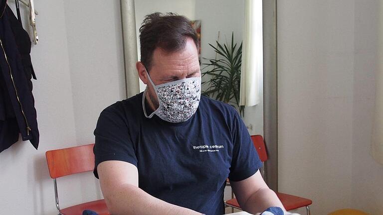 Stefan Franz bei der Behandlung mit Mundschutz und Handschuhen.  Foto: Bianca Volkert       -  Stefan Franz bei der Behandlung mit Mundschutz und Handschuhen.  Foto: Bianca Volkert