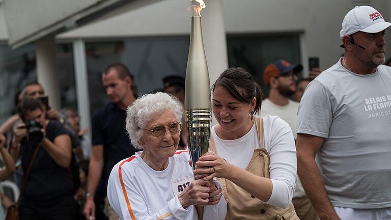 Mélanie Berger-Volle       -  Melanie Berger-Volle (M) hält in einem Seniorenheim in Saint-Etienne die olympische Fackel.