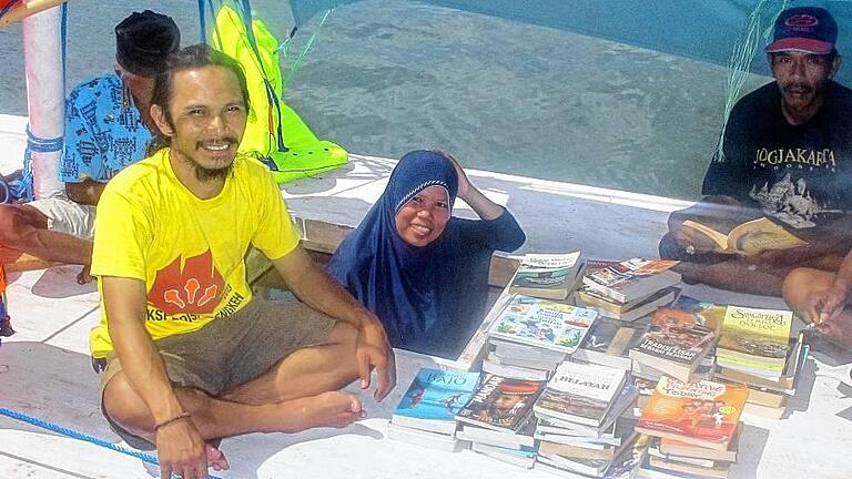 Frankfurter Buchmesse - Ehrengast Indonesien       -  Muhammad Ridwan (l) sitzt auf seiner schwimmenden Bibliothek.