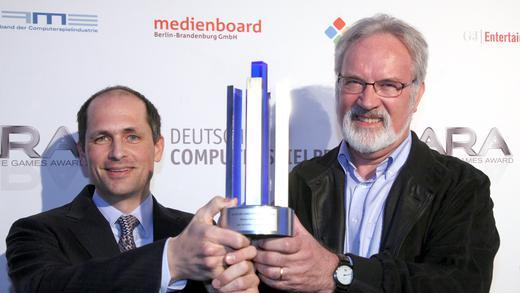 Deutsche Gamestage 2012       -  Thomas Bleyer und Max J. Cobbert (r) präsentieren am Donnerstag (26.04.2012) in Berlin bei der Verleihung des Deutschen Computerspielpreises 2012 und des Deutschen Games Award 2012 'LARA' ihren Preis für das beste mobile Spiel. Die Branchenverbände vergeben gemeinsam mit dem Beauftragten der Bundesregierung für Kultur und Medien im Rahmen der Deutschen Gamestage vom 24. bis zum 28. April die Auszeichnungen in insgesamt 10 Kategorien.