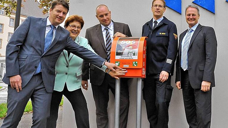Per Knopfdruck mit der Rettungsleitstelle verbunden: Landtagsabgeordneter Sandro Kirchner, Landtagspräsidentin Barbara Stamm, ZTM-Geschäftsführer Sebastian Dresbach, Brandamtsrat Michael Neis und TGZ-Geschäftsführer Alexander Zöller (von links) nehmen die erste Notrufsäule mit integriertem Defibrillator in Würzburg in Betrieb. Per Knopfdruck mit der Rettungsleitstelle verbunden: Landtagsabgeordneter Sandro Kirchner, Landtagspräsidentin Barbara Stamm, ZTM-Geschäftsführer Sebastian Dresbach, Brandamtsrat Michael Neis und TGZ-Geschäftsführer Alexander Zöller (von links) nehmen die erste Notrufsäule mit integriertem Defibrillator in Würzburg in Betrieb.