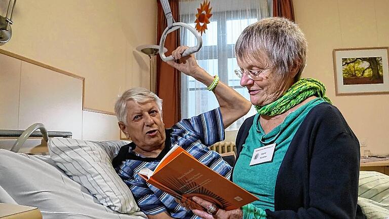 Im Juliusspital liest eine ehrenamtliche Hospizmitarbeiterin einem Patienten vor. Wird Hilfe erbeten, lässt der Hospizverein niemanden auf seinem letzten Weg allein.