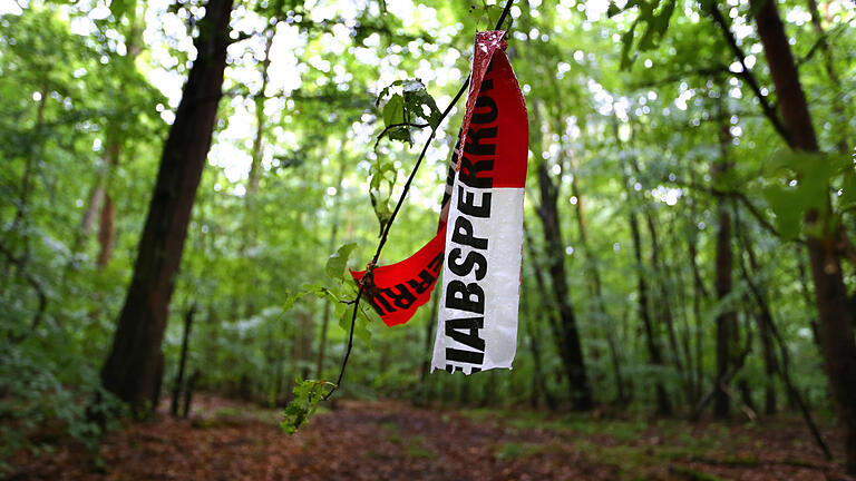 Fundstelle Entführungsopfer       -  ARCHIV - Reste von Absperrbändern der Polizei hängen am 18.06.2015 in einem Wald bei Kist (Landkreis Würzburg). In dem Waldstück wurde der zuvor entführte Sohn des Unternehmers Würth aufgefunden.