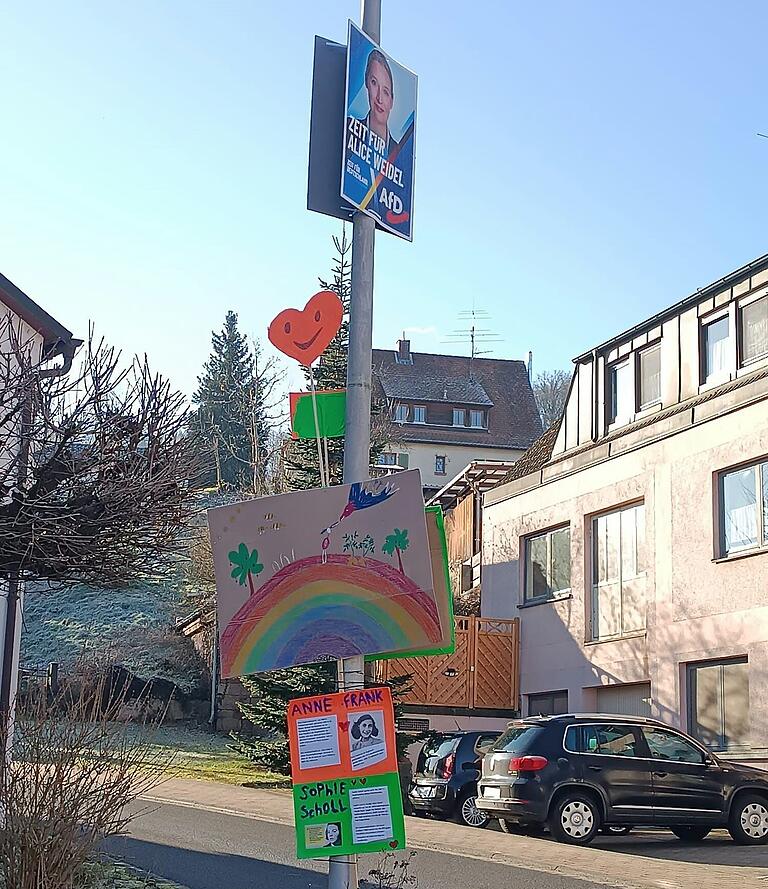 In Wernfeld haben Unbekannte – mutmaßlich Kinder – unter einem Plakat von AfD-Kanzlerkandidatin Alice Weidel einen Regenbogen und Plakate über Sophie Scholl und Anne Frank aufgehängt. Name der Fotografin ist der Redaktion bekannt. In Wernfeld haben Unbekannte – mutmaßlich Kinder – unter einem Plakat von AfD-Kanzlerkandidatin Alice Weidel einen Regenbogen und Plakate über Sophie Scholl und Anne Frank aufgehängt. Name der Fotografin ist der Redaktion bekannt.