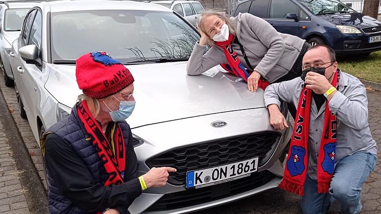 Auf geht's zum Tischtennis in die Heimat. Andreas Köber (links), seine Frau Ella und Albrecht Lediger weisen auf ihr spezielles Kölner Kfz-Kennzeichen hin. Es steht für den TSV 1861 Bad Königshofen.