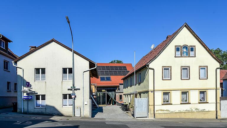 Hofansicht von der Raiffeisenstraße aus: Vorne rechts das Haus der Oma, hinten quer anstelle der Scheune das neue Familienhaus, links hinter dem Nebengebäude des Dreiseithofs ist der Anbau für die Wohnung der Schwiegereltern. Hofansicht von der Raiffeisenstraße aus: Vorne rechts das Haus der Oma, hinten quer anstelle der Scheune das neue Familienhaus, links hinter dem Nebengebäude des Dreiseithofs ist der Anbau für die Wohnung der Schwiegereltern.