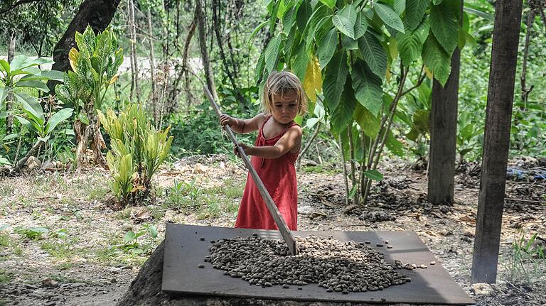 Statt Spielzeug Beschäftigung in der Natur: Romea bewegt die Kakaobohnen hin und her. Foto: Familie Schmitt Statt Spielzeug Beschäftigung in der Natur: Romea bewegt die Kakaobohnen hin und her. Foto: Familie Schmitt