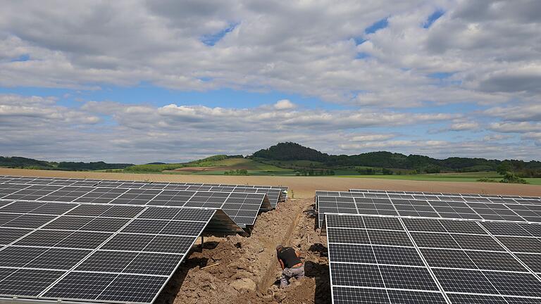 Das Stadtwerk Haßfurt und Digital Energy Solutions errichten im Gewerbegebiet Ost der Kreisstadt an der ehemaligen B26 - im Hintergrund die 'Hohe Wann' - ein Kombikraftwerk aus einer Photovoltaikanlage und einem Großspeicherprojekt zur Versorgung der umliegenden Unternehmen mit grünem Strom.