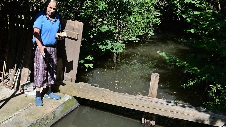 Karlheinz Stumpf zeigt die Stelle an seinem Wehr hinter dem Haus, in dem er die toten Fische entdeckte.