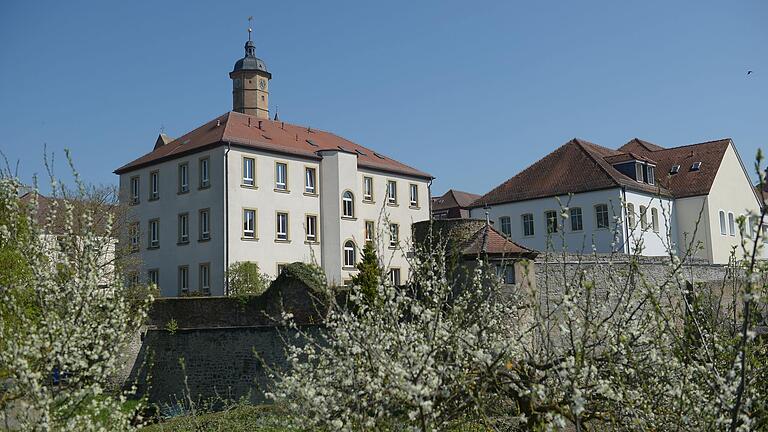 Blick auf die Mädchenrealschule Volkach über blühende Bäume hinweg.